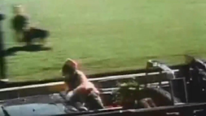 <p>Жаклин Кеннеди в панике пытается покинуть машину. </p>