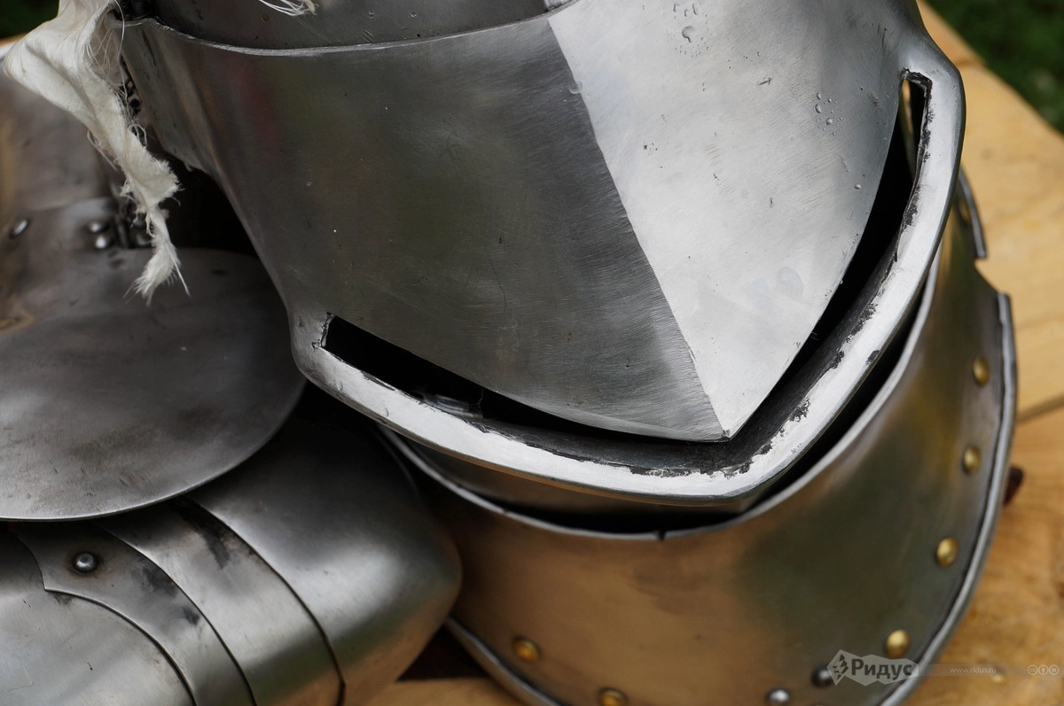 Турнирный шлем жестко закрепляемый на доспехе. Поскольку правилами состязания удары в голову разрешены, толщина металла шлема составляет порядка 20 мм., что хорошо видно на фото