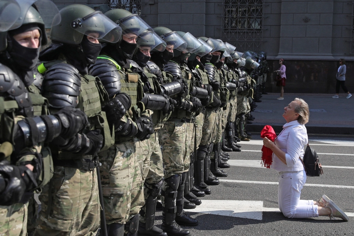 Сторонница оппозиции и военнослужащие внутренних войск Белоруссии во время акции протеста на проспекте Независимости в Минске.