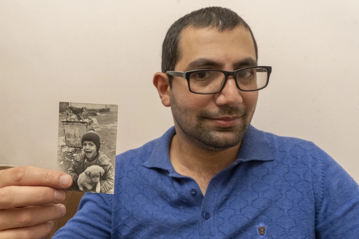 Тигран, житель Степанакерта в 2020 году, по окончании Второй Карабахской войны, со своей детской фотографией