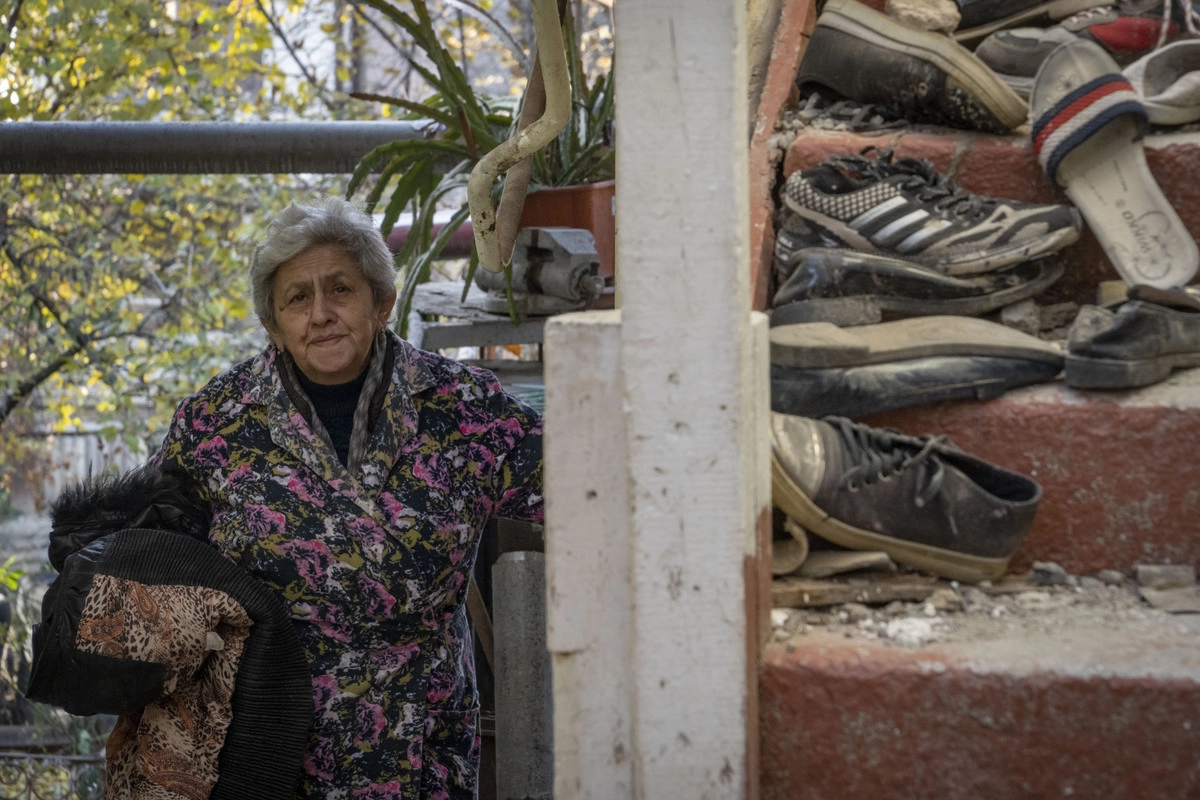 Жительница Степанакерта на крыльце своего полуразрушенного дома