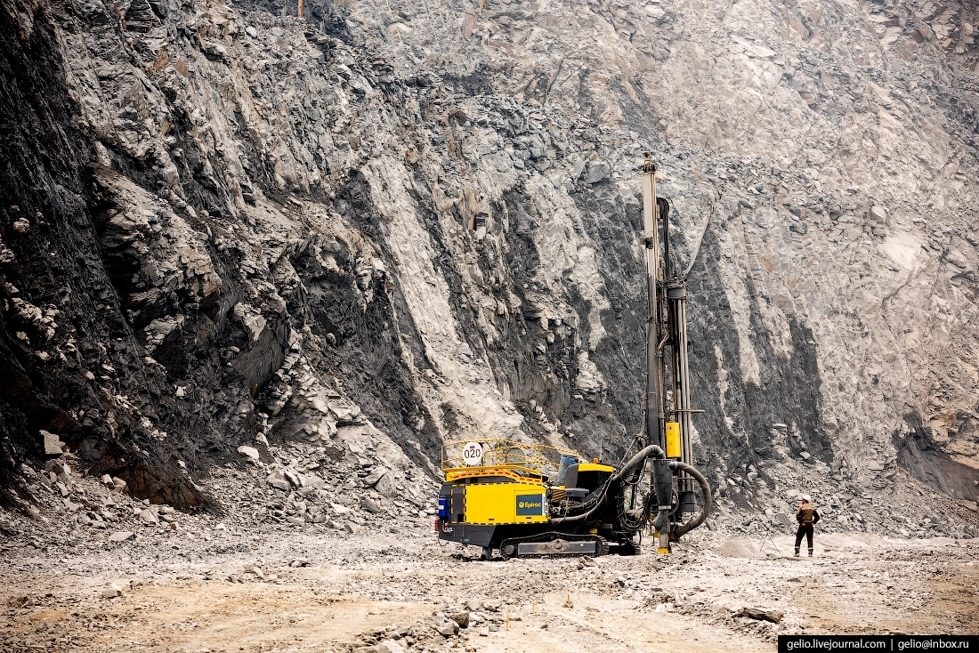 Подготовка скважины для взрывных работ. Глубина каждой скважины — до 6 метров. После взрыва породы на позицию выйдут экскаваторы и мощные самосвалы.