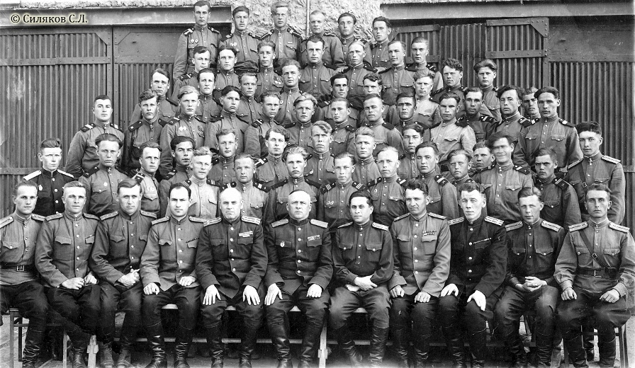 Личный состав 1-го испытательного управления (1 ИУ, в/ч 15646): военнослужащие 1-й и 2-й стартовых команд на фоне монтажного корпуса полигона Капустин Яр; в центре в первом ряду — А.Ф. Тверецкий; 20 апреля 1951 года. Фото из личного архива С.Л. Силякова kap-yar.ru