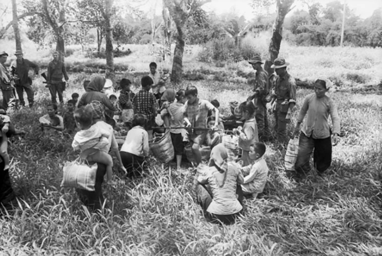 Крестьяне ждут, пока солдаты 1-го пехотного батальона закончат обыск в их деревне, 1968 год 