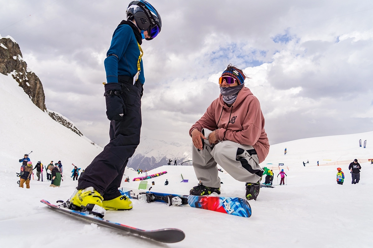 Про-райдер Аркадий Казаков инструктирует юного лыжника