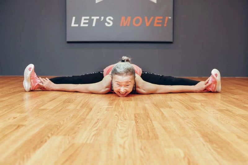 После завтрака женщина выполняет работу по дому, делает растяжку и смотрит телевизор После завтрака женщина выполняет работу по дому, делает растяжку и смотрит телевизор