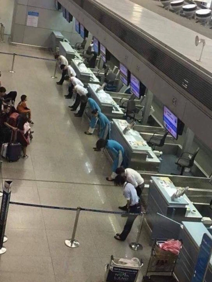 Сотрудники авиакомпании извиняются перед пассажирами из-за задержки рейса. 