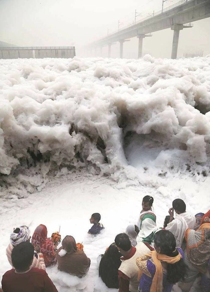 Индийцы молятся у реки Ямуна, которая вспенивается из-за огромного количества промышленных отходов. 