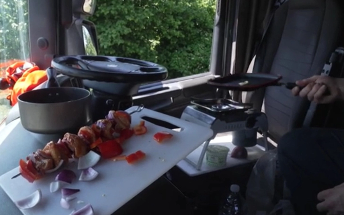 Дальнобойщик готовит еду на мини-кухне в грузовике
