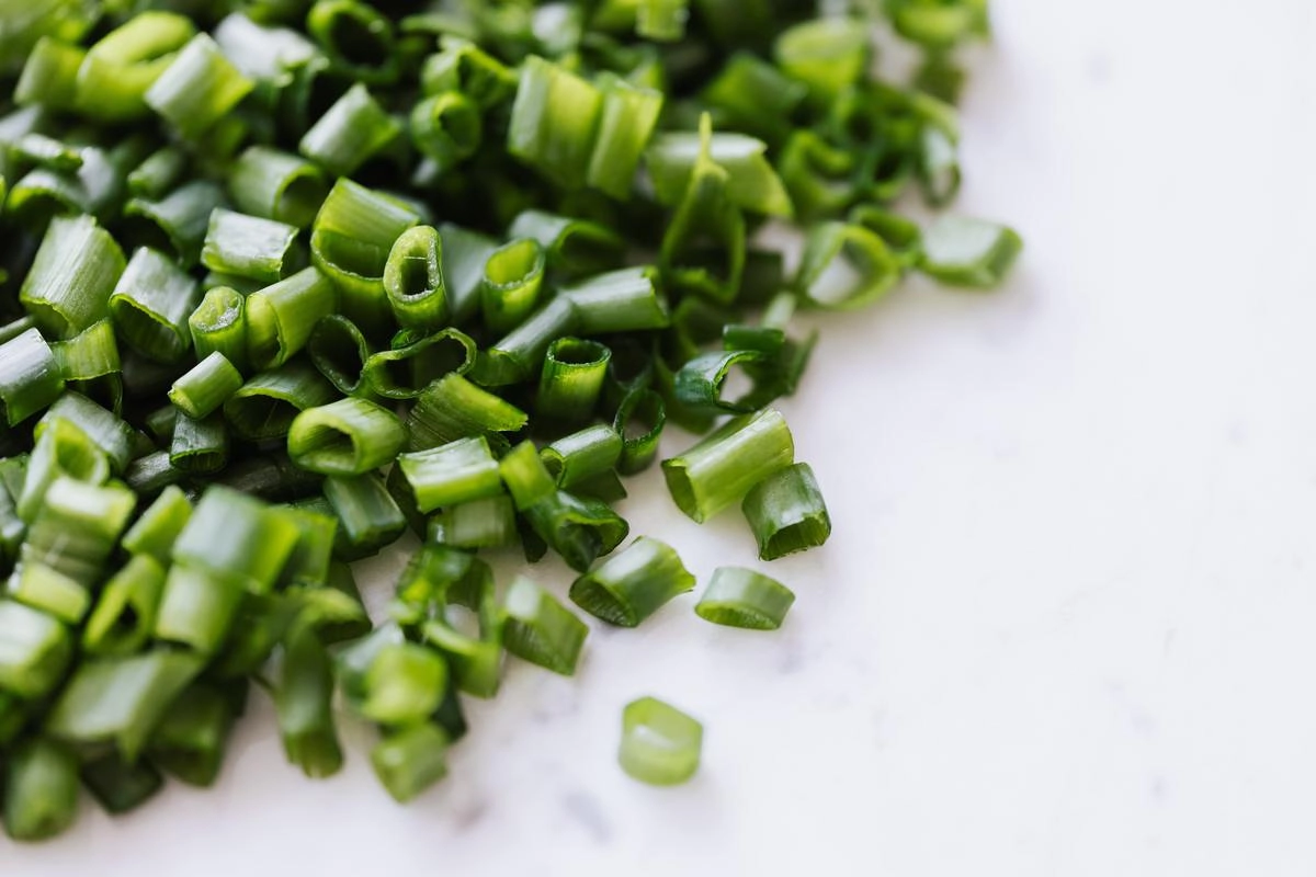 Мелко нарезанный зеленый лук и чеснок сделают яичницу более ароматной и слегка пикантной