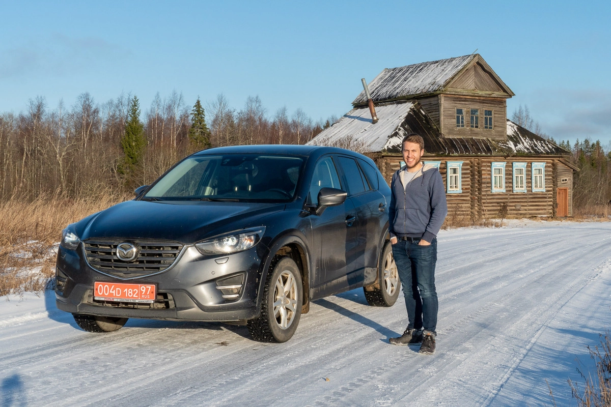 Паркер Уилсон на машине с красными номерами путешествует по России