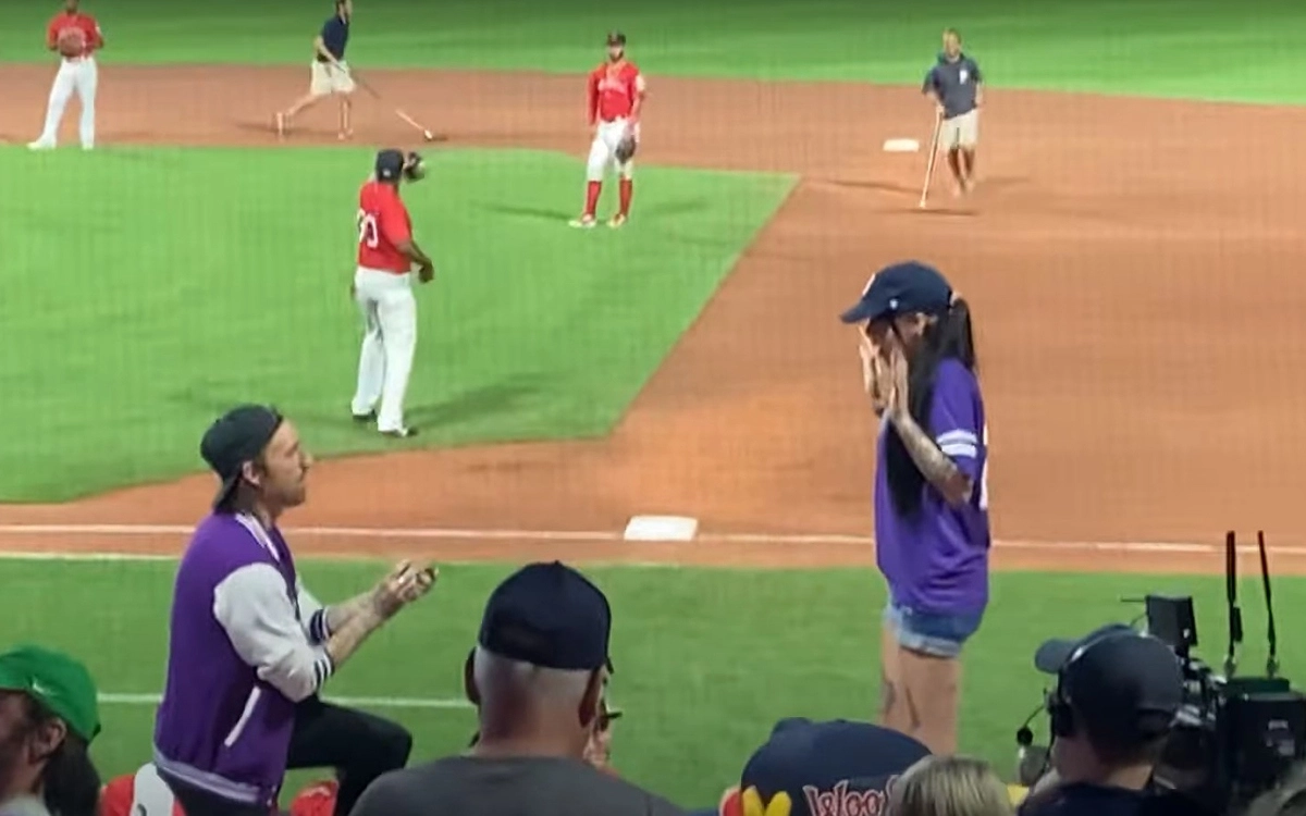 Парень встал на одно колено и под бурные аплодисменты толпы зрителей протянул девушке коробочку с кольцом.