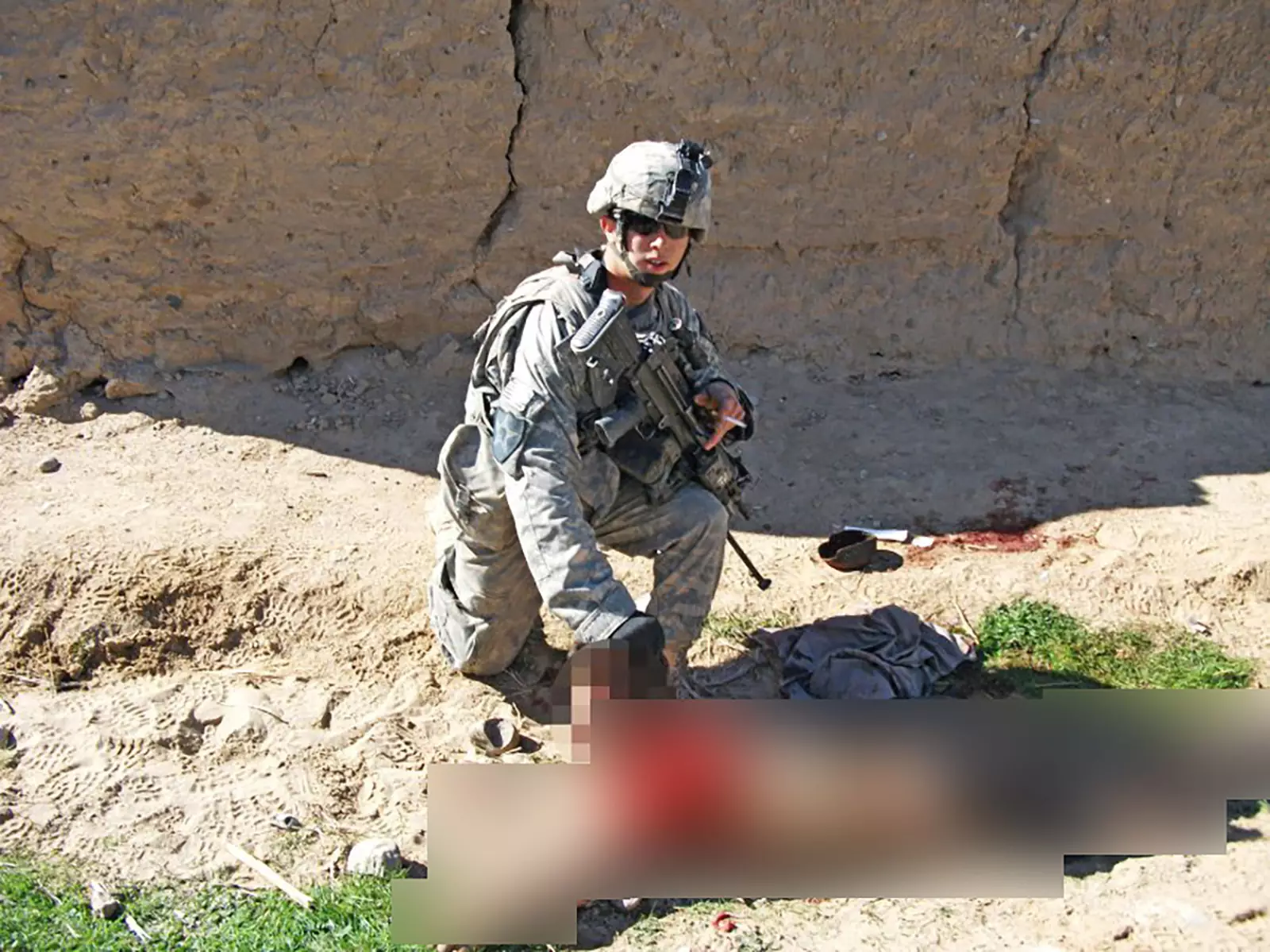 Американский военнослужащий позирует рядом с телом 15-летнего безоружного афганского подростка, убитого его подразделением 15 января 2010 г. в провинции Кандагар