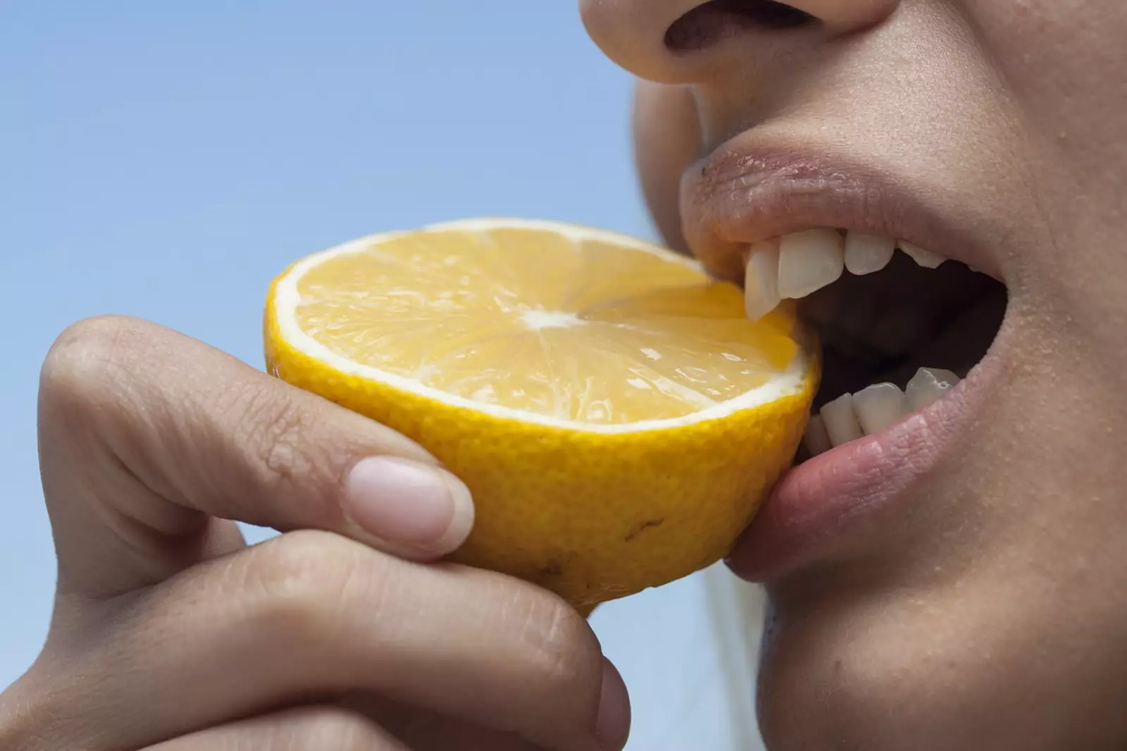 Девушка ест лимон 