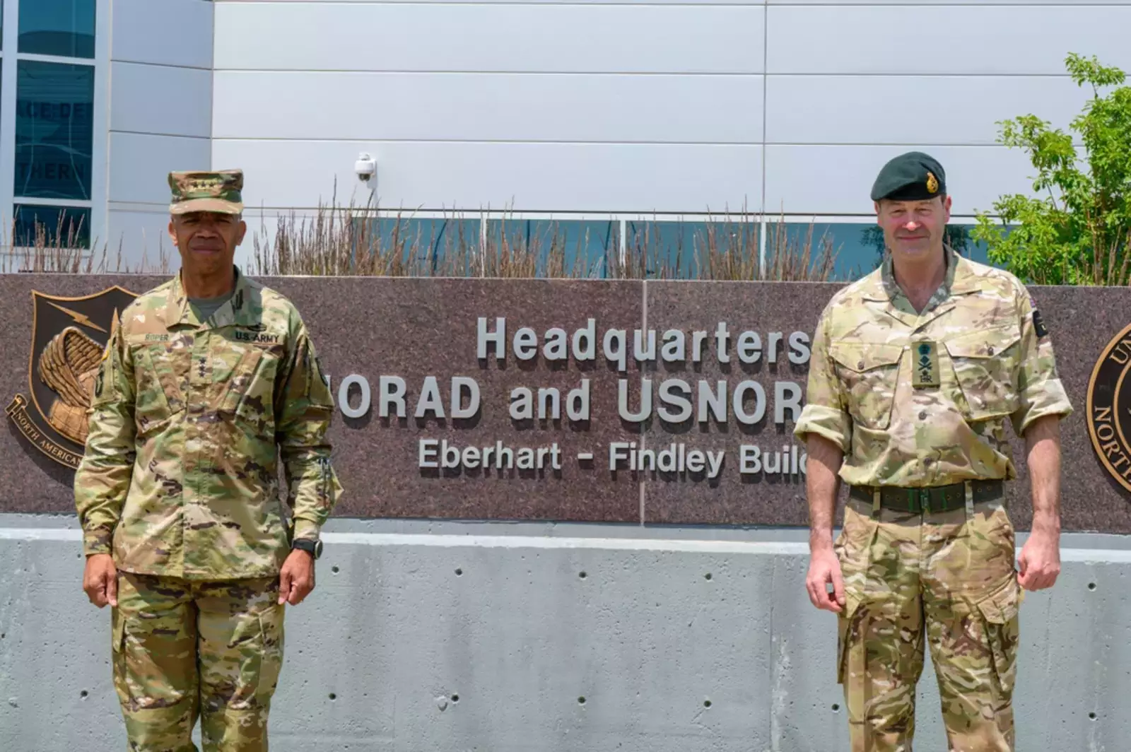 Патрик Сандерс (справа) и генерал-лейтенант армии США А.С. Ропер, зам. командующего Северным командованием позирует для фотографии перед зданием штаб-квартиры Эберхарта Финдли во время его визита в NORAD и USNORTHCOM на авиабазе Петерсон, штат Колорадо, 16 июля 2021 года