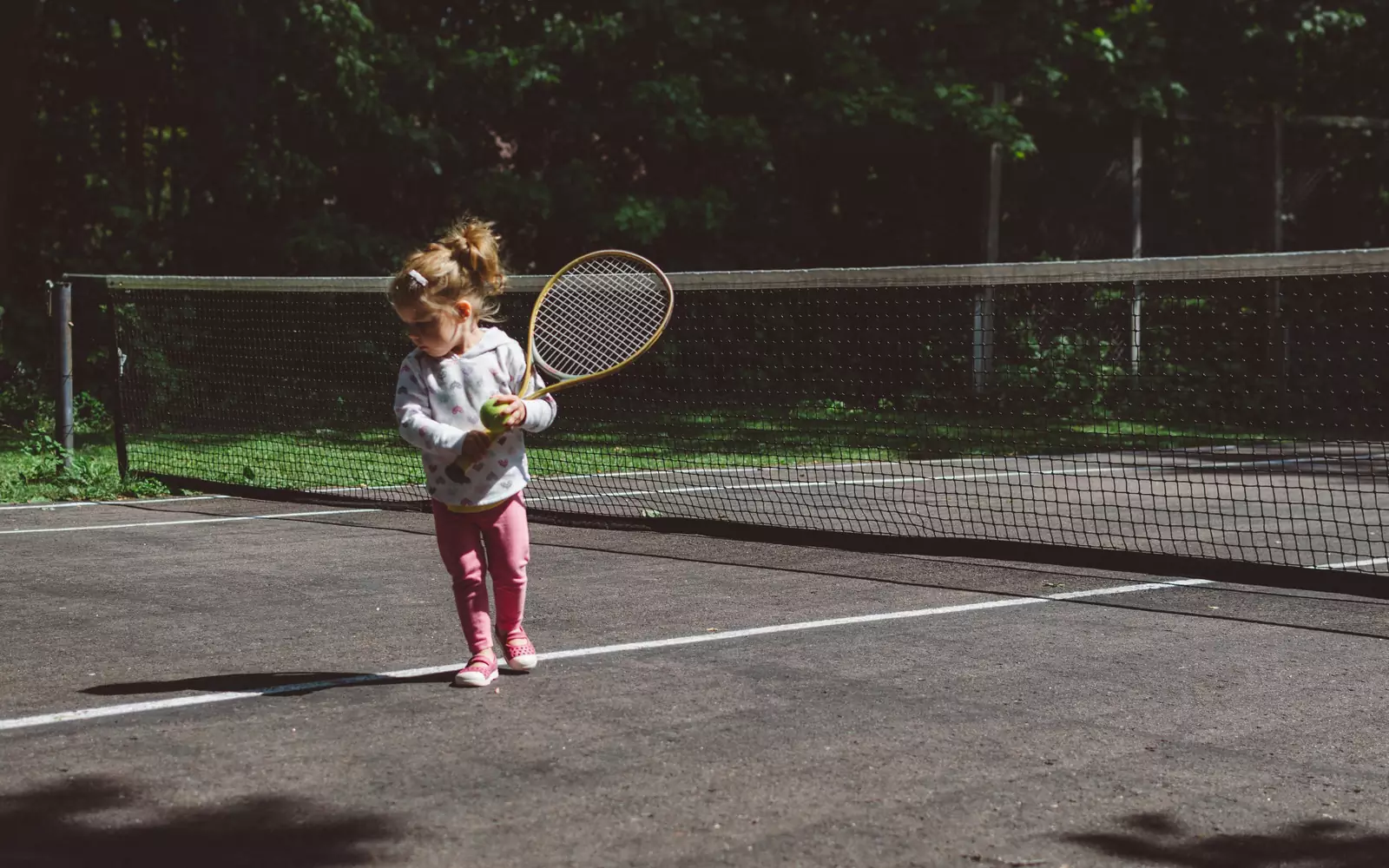 Девочка собирается играть в теннис.