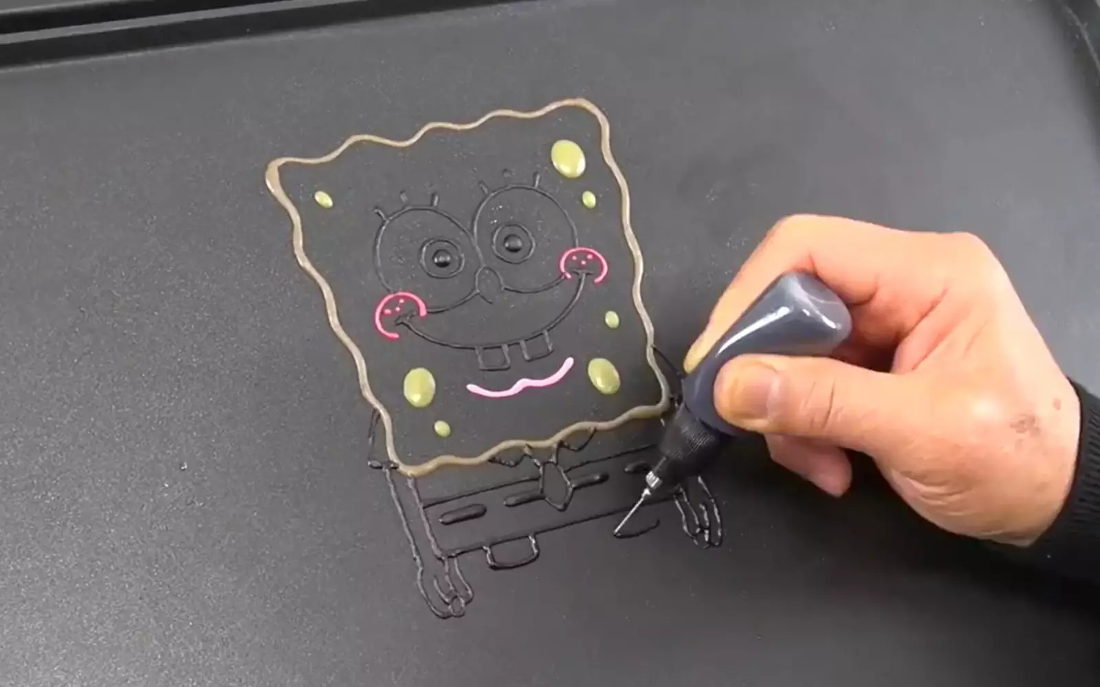 Для создания блинчика художники наносят на лист контур рисунка из теста с помощью специальной иглы.