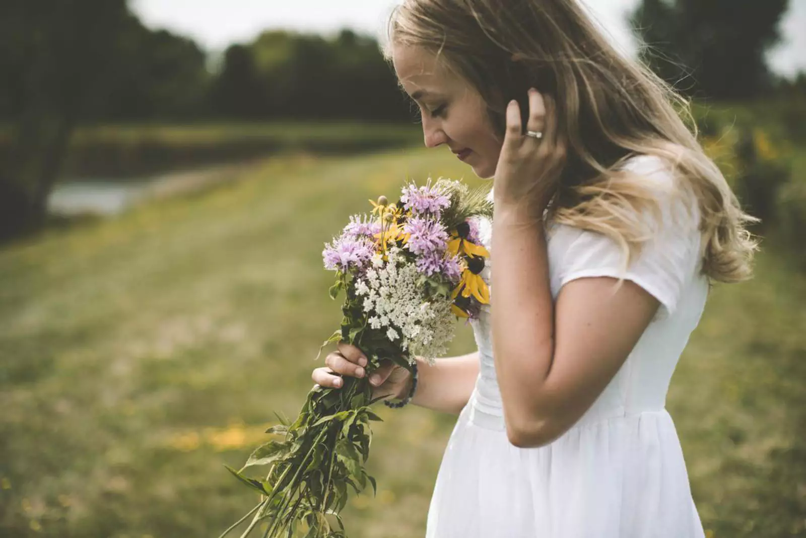 Девушка нюхает цветы.
