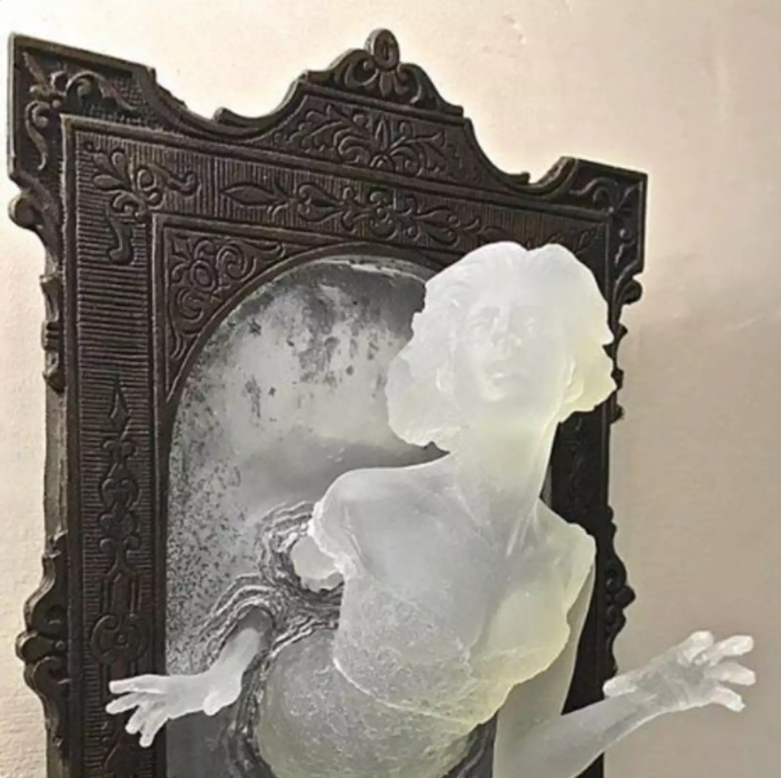 Скульптура в виде викторианского призрака, выплывающего из зеркала.
