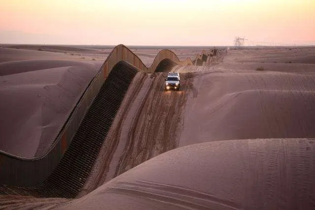 Этот снимок был сделан вдоль песчаных дюн Альгодонес в Южной Калифорнии. Забор, идущий вдоль дюн, является пограничным забором.