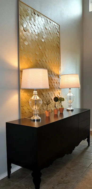 Если у вас есть большое пространство, которое нужно заполнить, но нечего туда положить, вырежьте круги из картона, покрасьте их аэрозольной краской, затем приклейте на холст, вставьте в рамку и повесьте!