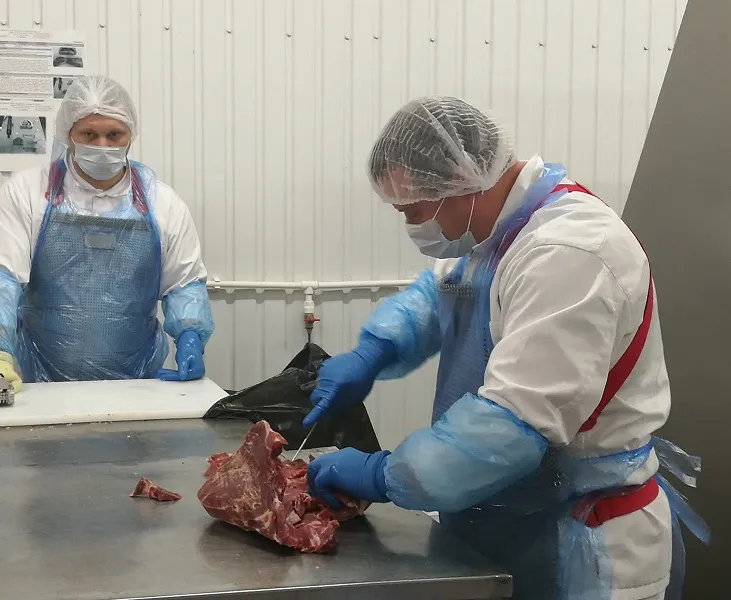 Мясо срезается с кости для последующего прессования в блок