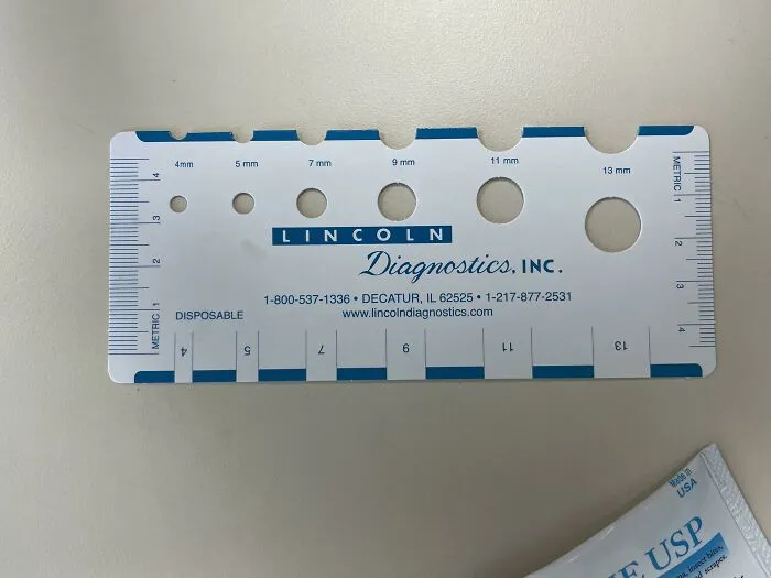 Линейка для измерения рубцов на руке после теста на аллергию.